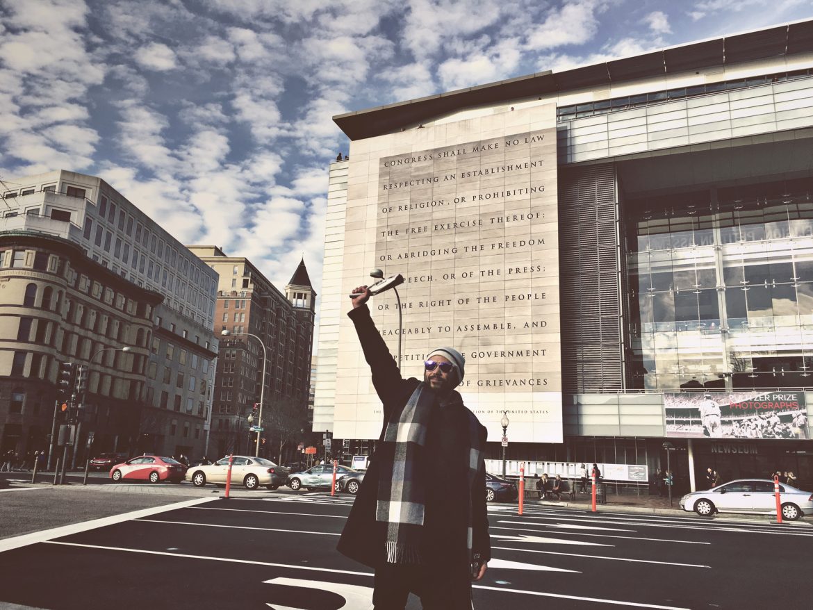 Angelo Lagdameo ‘carries the banner’ in front of the Newseum.
