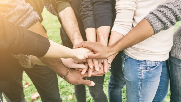 Group of Multiracial people stacking their hands together